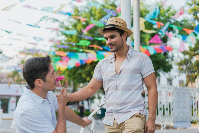LGBTQ+ couple enjoying a romantic day at a vibrant outdoor festival with colorful flags.